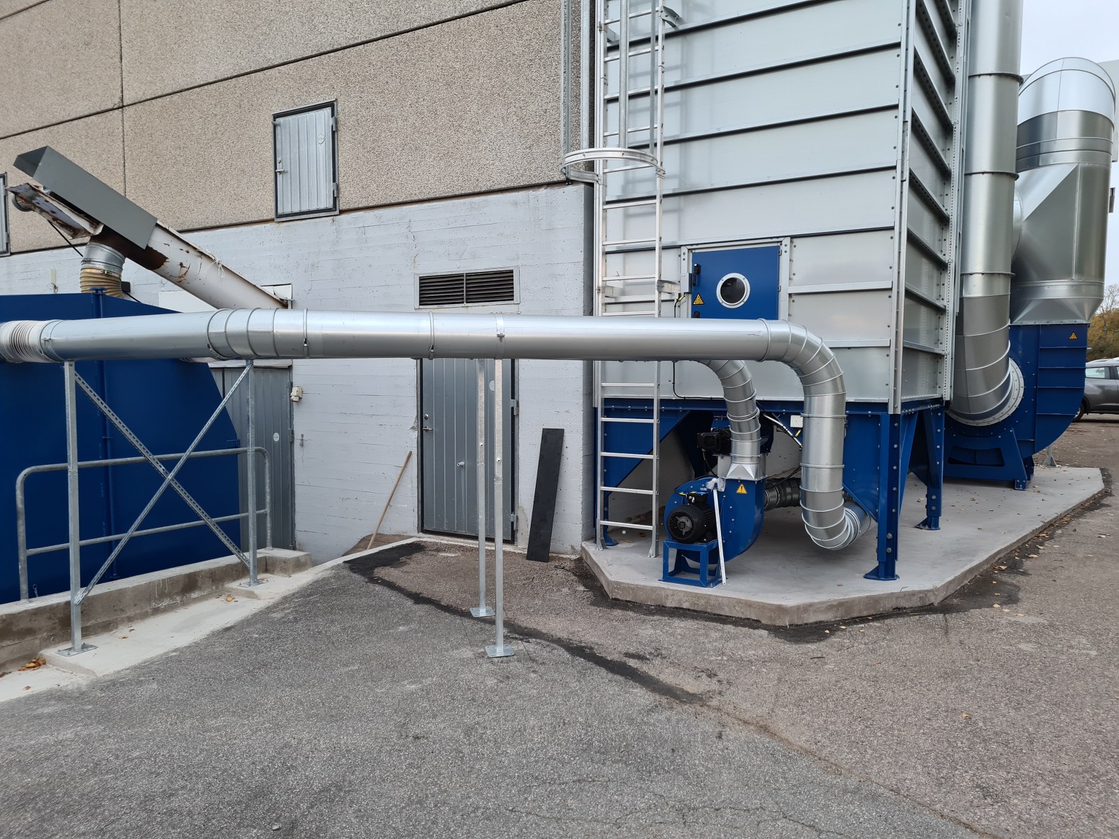 Filtre d’aspiration des copeaux, réseau de gaines d’évacuation et ventilateur bleu à côté de l’usine