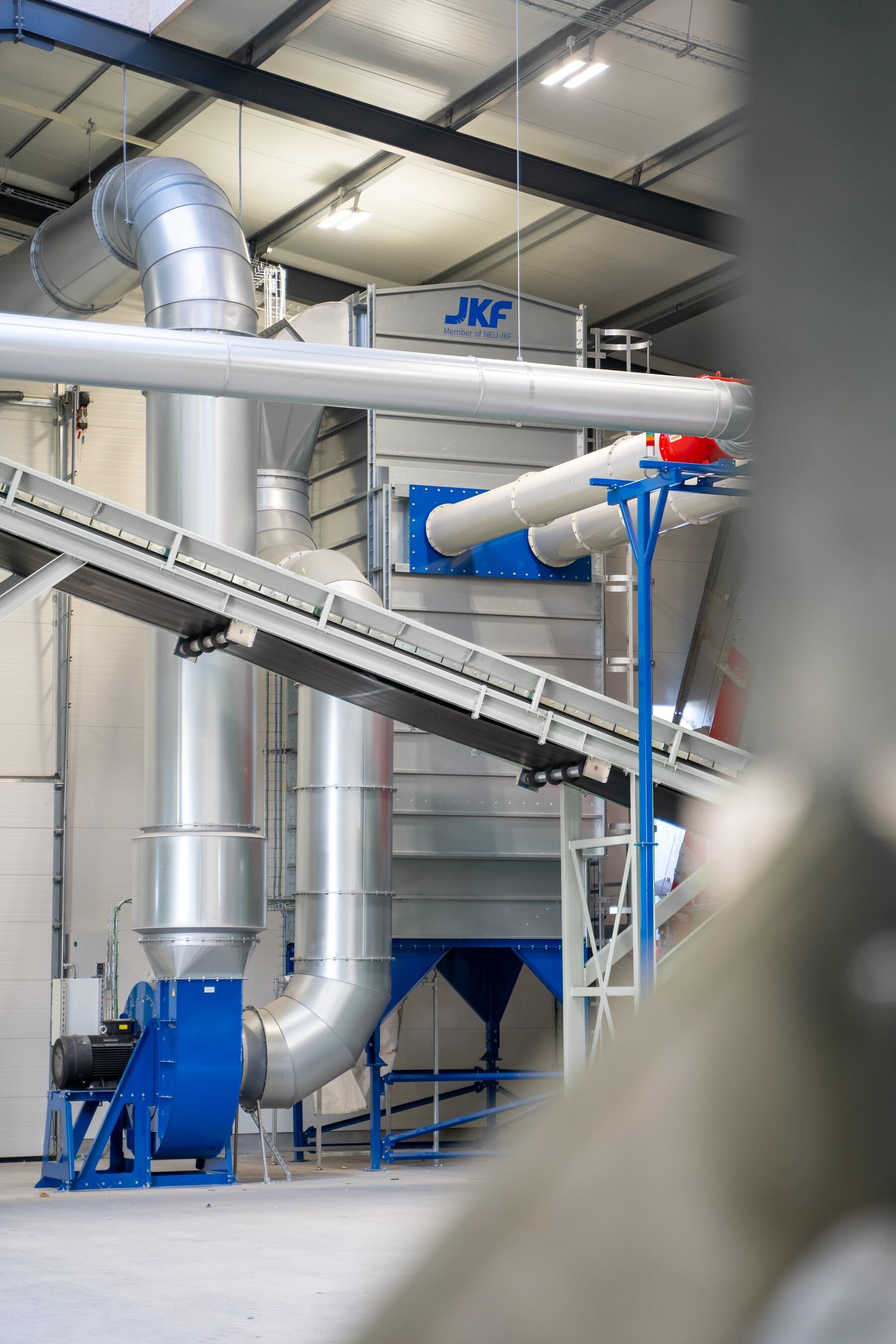Installation JKF comprenant un filtre, un ventilateur et un réseau de gaines à côté d’un convoyeur de process dans l’installation de recyclage Viggo Bendz